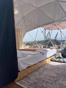 a bed in a tent with a view of the ocean at Glamping ROSE (Luštica Bay) in Radovici