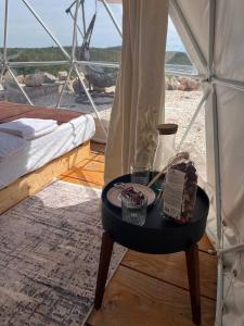 拉多維奇的住宿－Glamping ROSE (Luštica Bay)，帐篷顶上一张带一盘食物的桌子