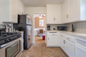 a kitchen with white cabinets and a black refrigerator at HUGE Cozy 2bd 1ba Apt w Office & Back Yard in Los Angeles
