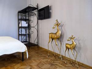two gold deer statues on a wall next to a bed at Veranda Boutique Hotel Kutaisi in Kutaisi