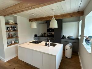 a kitchen with a white island in a room at Kapitänshaus von 1712 - neu saniert in Nieblum +13 photos