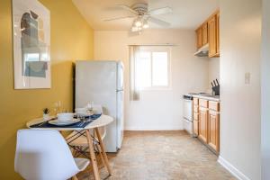 a kitchen with a white refrigerator and a table at Spacious STUDIO apt with everything you need in Los Angeles