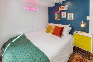 een slaapkamer met een wit bed en een blauwe muur bij Stylish 2 Bedroom Apt Steps From Regis Tennyson St in Denver