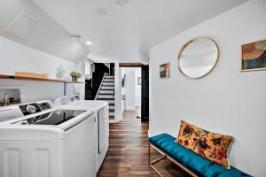 een witte wasmachine en droger in een keuken met een spiegel bij Stylish 2 Bedroom Apt Steps From Regis Tennyson St in Denver