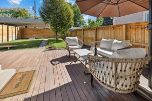 een patio met een tafel en stoelen en een parasol bij Stylish 2 Bedroom Apt Steps From Regis Tennyson St in Denver