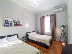 a bedroom with two beds and a window with a chandelier at Veranda Boutique Hotel Kutaisi in Kutaisi