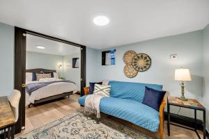 sala de estar con sofá azul y cama en Charming & Updated Garden Level in Heart of Denver en Denver