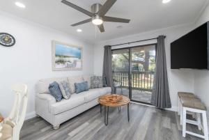 uma sala de estar com um sofá e uma ventoinha de tecto em Remodeled Corner Unit 2 2 Overlooking the Lagoon em Hilton Head Island