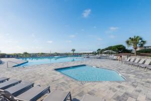 uma grande piscina com espreguiçadeiras e um resort em Remodeled Corner Unit 2 2 Overlooking the Lagoon em Hilton Head Island