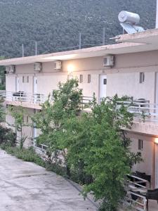a large white building with trees in front of it at STUDIOS MONA in Agios Georgios