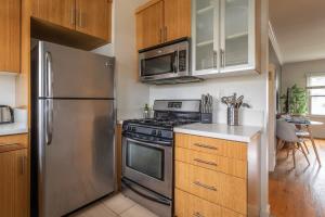 a kitchen with stainless steel appliances and wooden cabinets at Spacious 2BR filled with Sunshine and fast WIFI in Los Angeles