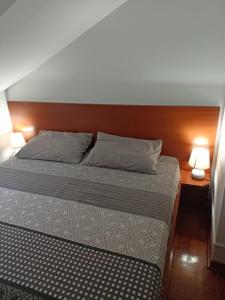 a bedroom with a bed with two lamps on it at Apartman Jasmin in Vrnjačka Banja