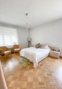 um quarto com uma cama branca e piso em madeira em Elegance ,Space & Luxury in Brussels em Bruxelas