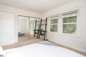 1 dormitorio con cama, escritorio y espejo en Cozy Massive 2BR Washer Dryer in Unit by LAX, en Los Ángeles