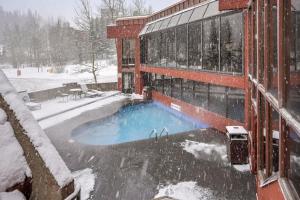a building with a swimming pool in the snow at NEW Ski-in Ski-Out at Peak 9 Walk to Super Chair Lift in Breckenridge
