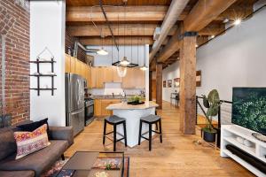 丹佛的住宿－NEW Downtown Denver City Loft-Great Walkability，厨房以及带沙发和桌子的客厅。