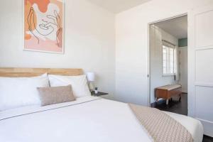 a bedroom with a large white bed and a mirror at Very Peaceful 2BR with Desks & Super Fast Wifi in Los Angeles