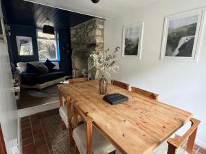 uma sala de jantar com uma mesa de madeira e um sofá em Terfyn Cottage em Dinorwic