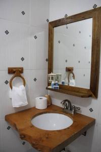 y baño con lavabo y espejo. en Villa con Hermosa Vista a las Montañas a Pasos del Río @drvacationsrental en Bonao