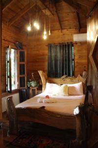 1 dormitorio con 1 cama en una cabaña de madera en Villa con Hermosa Vista a las Montañas a Pasos del Río @drvacationsrental en Bonao