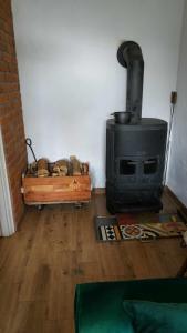 a living room with a stove and a wooden floor at Domek z kominkiem, Ukta 63, Mazury, in Ruciane-Nida