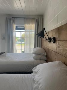 1 dormitorio con 2 camas individuales y ventana en Triangle Motel en Red Bluff