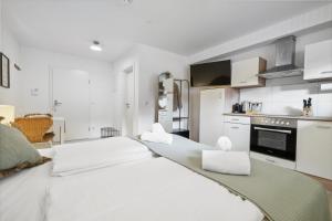 eine Küche mit 2 weißen Betten in einem Zimmer in der Unterkunft Casa Oasis I: Modern, Nespresso & Thermennähe in Bad Füssing