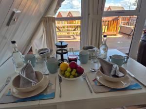 a table with plates and bowls of fruit and wine bottles at SEA VIEWS at Coastal chalet in Kingsdown Park with pool & tennis court onsite in Kingsdown