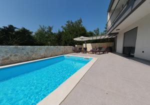 a swimming pool in the backyard of a house at Villa Lily in Privlaka