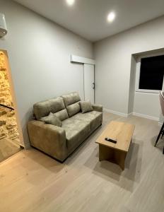 ein Wohnzimmer mit einem Sofa und einem Couchtisch in der Unterkunft El Reloj De La Villa in Valdefuentes
