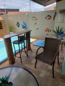 un patio con 2 sillas, una mesa y una barra en CASA próximo PRAIA para temporada, en Aracaju