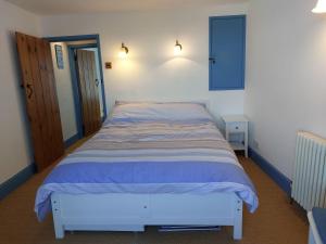 a bedroom with a bed with a blue and white bedspread at 2 Bed cottage in a fantastic sea front setting in Appledore
