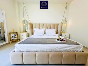 a bedroom with a large bed with a tufted headboard at NaDar Luxury House - Green Coast in Himare
