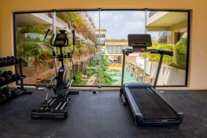 een fitnessruimte met cardio-apparatuur en uitzicht op een zwembad bij Xamira Tulum Studios in Tulum