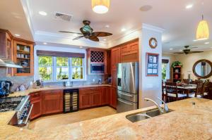 a kitchen with wooden cabinets and stainless steel appliances at Honu La'e in Koloa