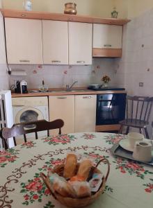 a kitchen with a table with a basket of bread at La maison di Anna in Terlizzi