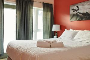 a bedroom with a large white bed with red walls at NN - The Kit - Downtown 1-bed 1-bath in Whitehorse