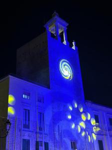 a large building with a clock tower with blue lights at La maison di Anna in Terlizzi