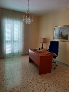 an office with a desk and a chair and a chandelier at La maison di Anna in Terlizzi