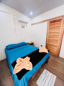 a bedroom with a blue bed with two towels on it at Apartamentos en el Centro de Puerto Viejo in Puerto Limón