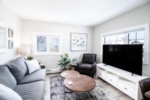 a living room with a couch and a flat screen tv at NN - Flats on 4th #3 - Downtown 1-bed 1-bath in Whitehorse