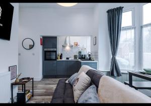 a living room with a couch and a kitchen at Cozy 1BDR - Bay Windows & Superb Location in Manchester