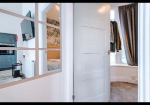 a door leading to a bedroom with a mirror at Cozy 1BDR - Bay Windows & Superb Location in Manchester