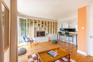 a living room with a table and chairs and a kitchen at Charming 2BR Flat, Holloway Road in London