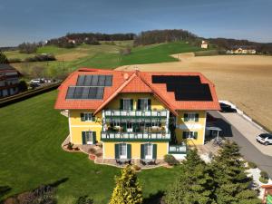 ein Haus mit Sonnenkollektoren auf dem Dach in der Unterkunft Hotel Garni Thermenglück in Unterlamm