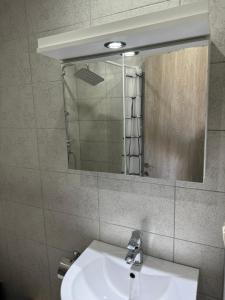 ein Badezimmer mit Waschbecken und Spiegel in der Unterkunft Adoniss apartmentss 1 in Paralia Dionisiou + 3 Fotos