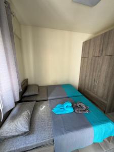 ein Schlafzimmer mit zwei Betten mit blauer Kleidung darauf in der Unterkunft Adoniss apartmentss 1 in Paralia Dionisiou