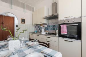 una cucina con tavolo, piatti e bicchieri da vino di Home Romana Centro Nettuno a Nettuno