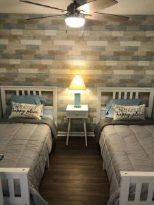 een slaapkamer met 2 bedden en een tafel met een lamp bij Gorgeous 2 BR/2 BR Newly Renovated BeachFront Condo in Myrtle Beach