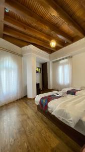 1 dormitorio con 1 cama grande y 2 ventanas en Mahbubakhon Hotel, en Bukhara